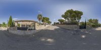 a 360 degree image of a street corner with a driveway, fence, and gate