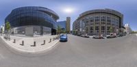 a spherical photo of a street corner and several buildings with cars parked in front of it