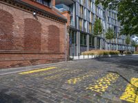 a long empty brick street with tall buildings in the background on a sunny day with some people walking around