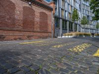 a long empty brick street with tall buildings in the background on a sunny day with some people walking around