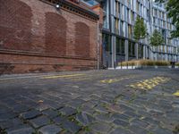 a long empty brick street with tall buildings in the background on a sunny day with some people walking around