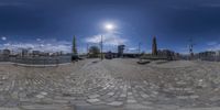 a fisheye lens of an old town in europe with many people walking around it