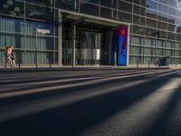 the sunlight reflects from several windows in a large building onto the street from outside the building