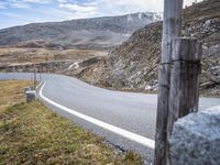 a man is riding a motorcycle in the mountains on a road that is winding through the grass