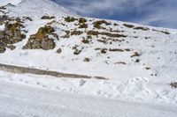 person skiing down the side of the mountain on a slope of snow with rocks in the distance