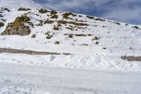 person skiing down the side of the mountain on a slope of snow with rocks in the distance