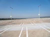 a empty parking lot with several lights in front of it and a hill on the side