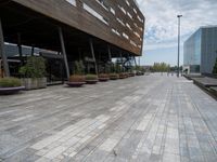 a photo of some buildings some people and plants on a brick path and pavements