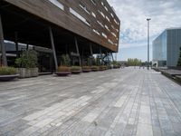 a photo of some buildings some people and plants on a brick path and pavements