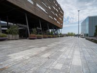 a photo of some buildings some people and plants on a brick path and pavements