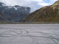 a person riding a motorcycle down the road next to a mountain and valley in front of them