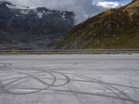 a person riding a motorcycle down the road next to a mountain and valley in front of them