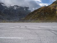 a person riding a motorcycle down the road next to a mountain and valley in front of them