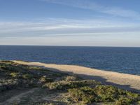 the ocean is empty of people on the beach by the sand path near the shore