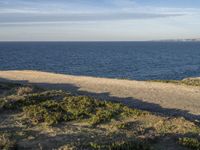 the ocean is empty of people on the beach by the sand path near the shore