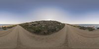 a 360 - angle image of a trail in a desert area near the ocean at sunset