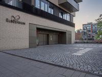 the entrance to an office block with some doors on either side and brick floors on each floor