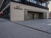 the entrance to an office block with some doors on either side and brick floors on each floor