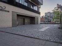 the entrance to an office block with some doors on either side and brick floors on each floor