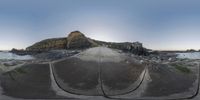 the road is made up like an upside down hill and a very big rock out in the distance