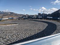 a car at the entrance to a large industrial site in a mountainous area with mountains in the background