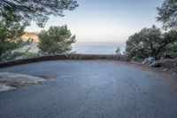 a curve and an ocean as seen from a road on the cliffs side of a mountain