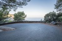 a curve and an ocean as seen from a road on the cliffs side of a mountain