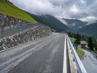 mountains with a fence separating it and the road beside it to a cliff, below them