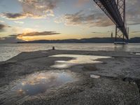 sunset with sky and water reflecting the silhouette of the bay bridge, bay, or shore