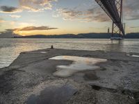 sunset with sky and water reflecting the silhouette of the bay bridge, bay, or shore