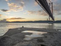 sunset with sky and water reflecting the silhouette of the bay bridge, bay, or shore