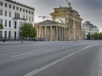 an empty street in front of two large buildings and a statue on a steeple