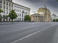 an empty street in front of two large buildings and a statue on a steeple