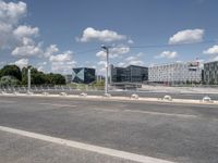 a street with a bike on a bridge next to a building and road with some wires