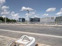 a street with a bike on a bridge next to a building and road with some wires