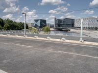 a street with a bike on a bridge next to a building and road with some wires