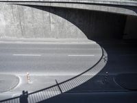 a car is on the street in front of a bridge that overlooks the road