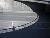 a car is on the street in front of a bridge that overlooks the road