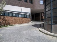 the street is paved with rocks and grass in front of a building and a walkway near the building