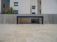 the gray concrete walls of a building have a line of steps on the left side