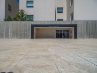 the gray concrete walls of a building have a line of steps on the left side