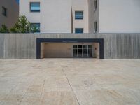 the gray concrete walls of a building have a line of steps on the left side