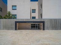 the gray concrete walls of a building have a line of steps on the left side