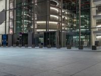 a very big square with some stairs and windows at night time with a fire hydrant sitting in front of it