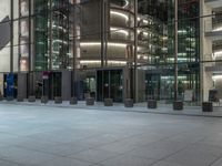 a very big square with some stairs and windows at night time with a fire hydrant sitting in front of it