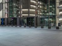 a very big square with some stairs and windows at night time with a fire hydrant sitting in front of it