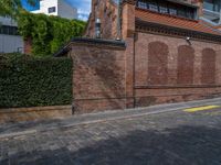 a long empty brick street with tall buildings in the background on a sunny day with some people walking around