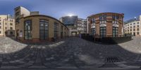 three buildings and some windows with the sun behind them on a circular street view 360 lens