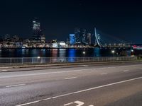 an empty freeway with the city skyline in the distance at night time in this image