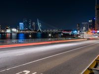 an empty freeway with the city skyline in the distance at night time in this image